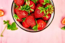 Ripe red strawberries on pink table, Strawberries in bowl. Fresh strawberries. Beautiful strawberries. Diet food. Healthy, vegan. Top view. Flat lay.
