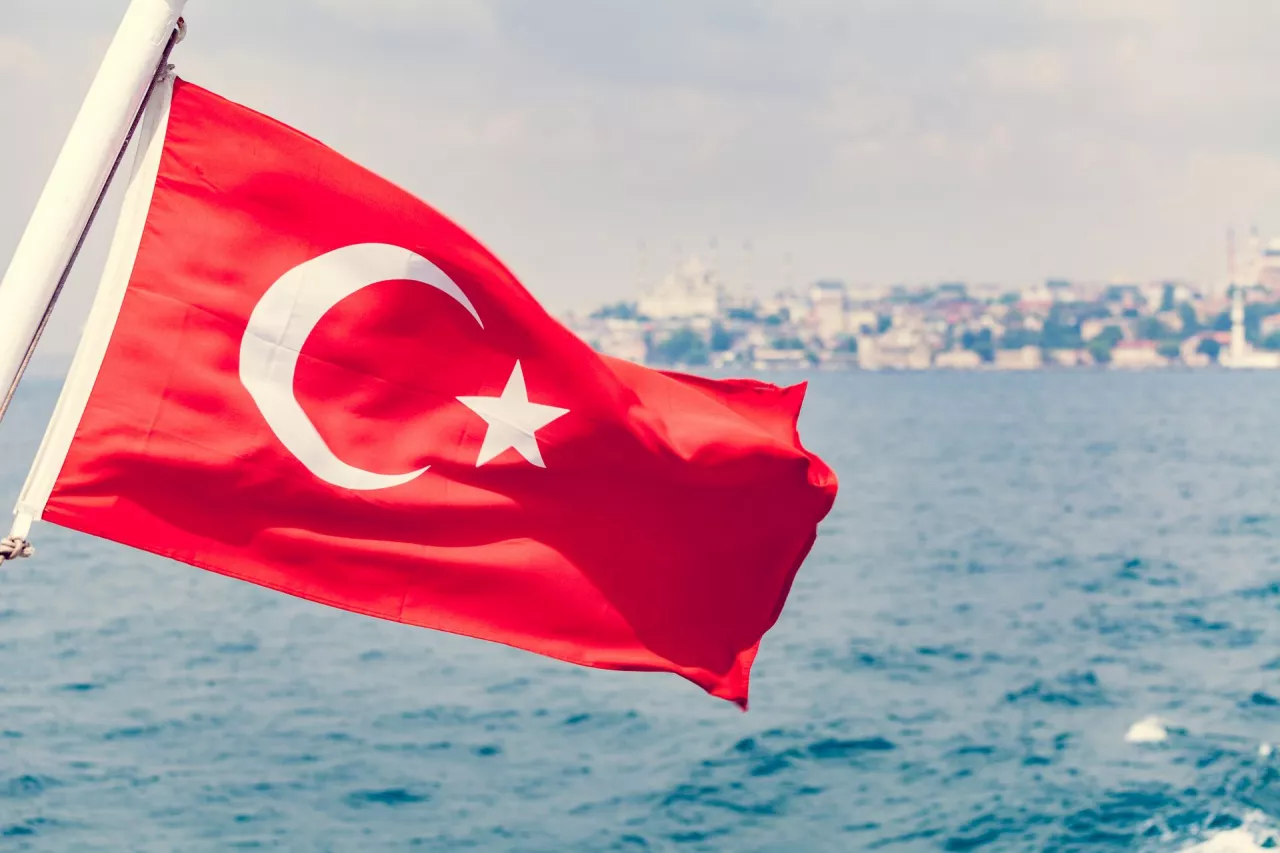 Turkey flag waving over blue sky and sea background