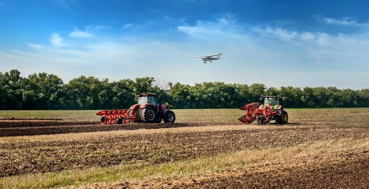 Bilogirya, Khmelnytsky region, UKRAINE - August 19, 2021: tractors with seeder at the demonstration of agricultural machinery, exhibition ”Battle of agrotitans” seeder competition, and airplan at sky