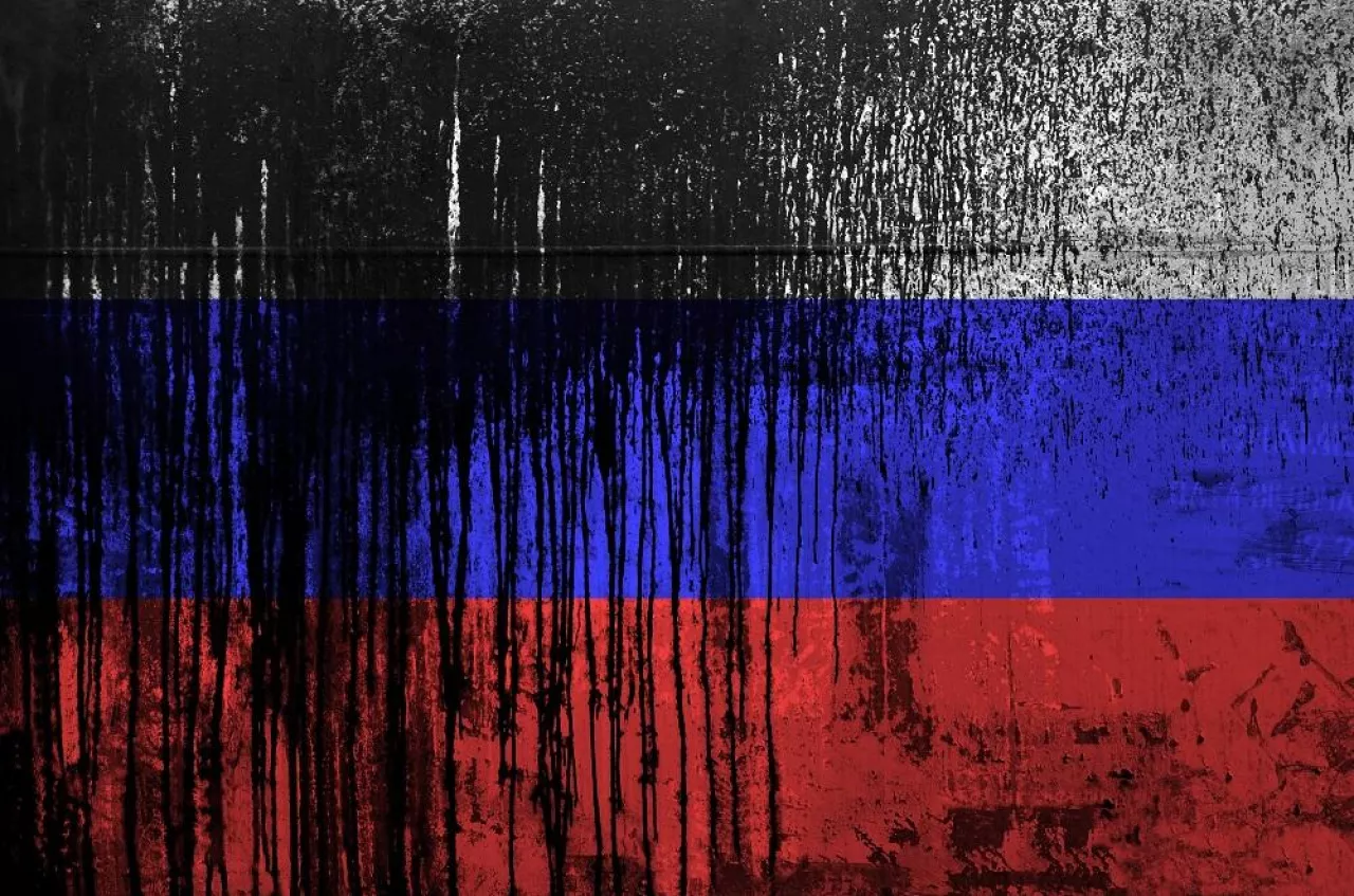 Russia flag depicted in paint colors on old and dirty oil barrel wall close up. Textured banner on rough background