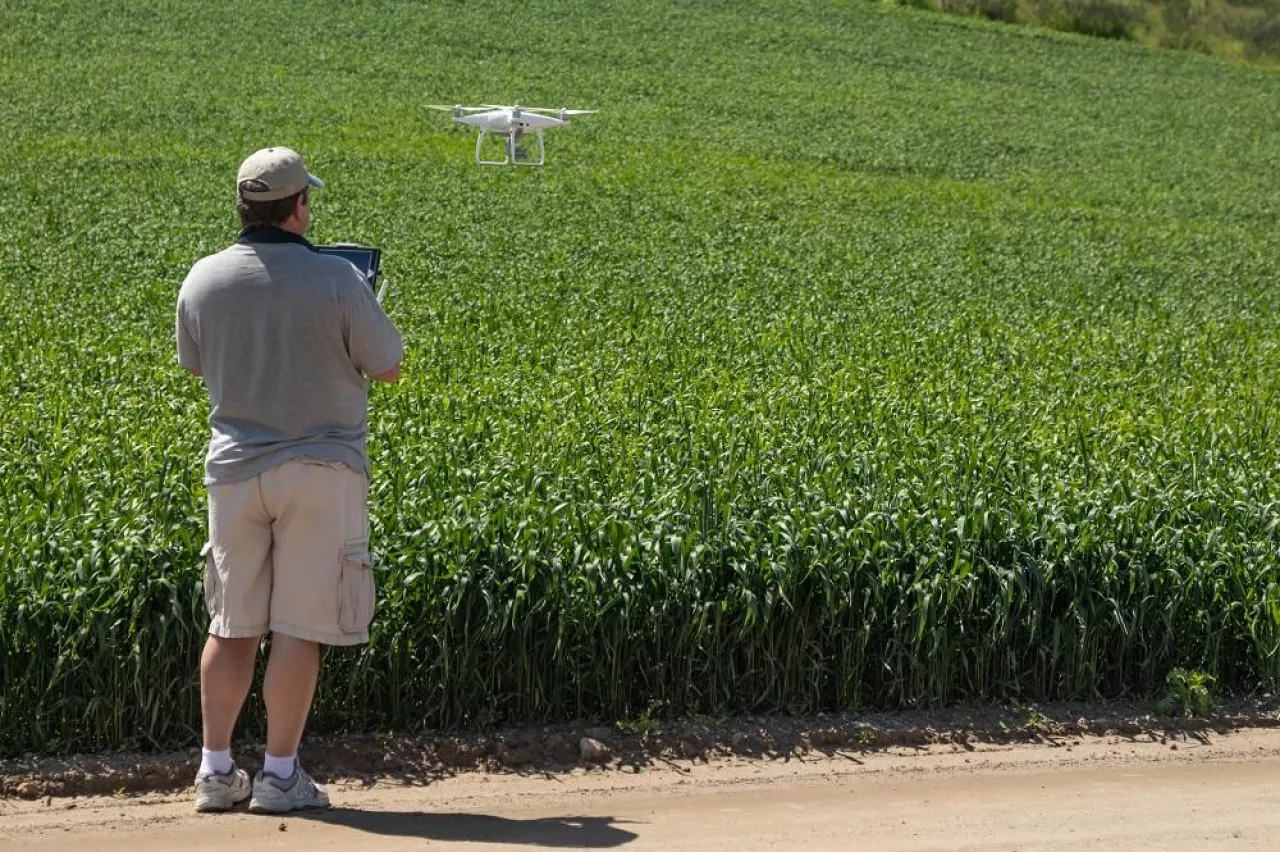 Pilot Flying Unmanned Aircraft Drone Gathering Data Over Country Farmland Field.