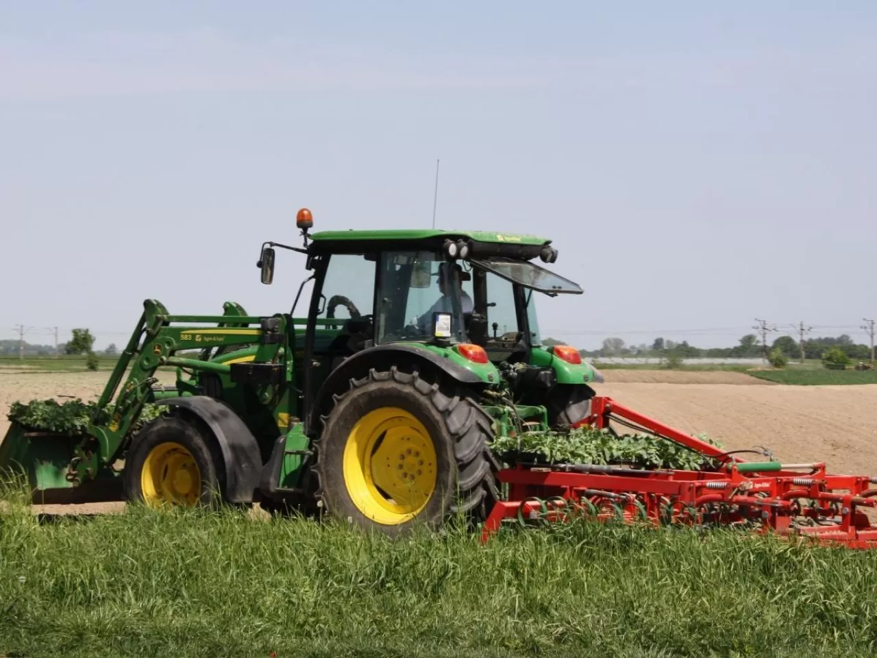 ciągnik John Deere z kultywatorem na polu