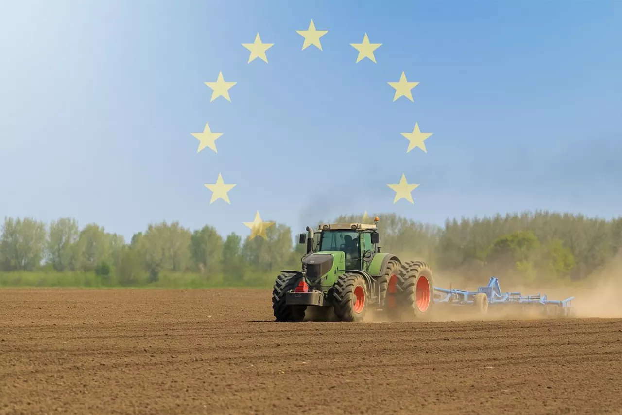 Ciągnik rolniczy z kultywatorem z symbolami UE